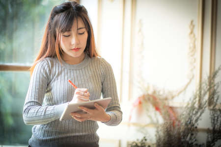 Girl texting on the tablet computer ,With space for text ads.の写真素材