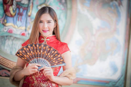 Asian Chinese woman in Traditional Chinese holding blow