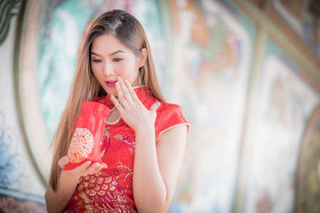 Asian Chinese woman in Traditional Chinese hold Gift Bag,by background ambience China .の写真素材