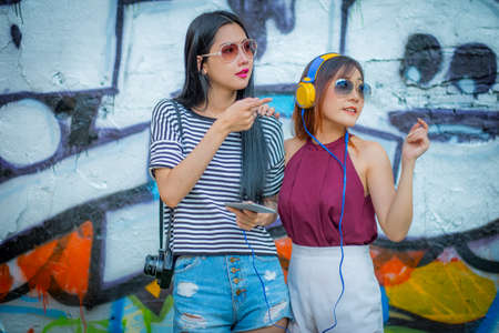Fashion lifestyle, Beautiful two young woman.  with abstract graffiti art. ,And fashion sunglasses.の写真素材