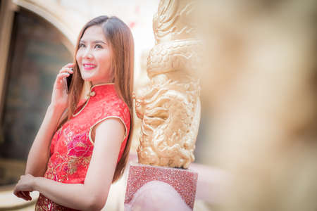 Asian Chinese woman in Traditional Chinese and hold telephone,by background ambience China ..の写真素材