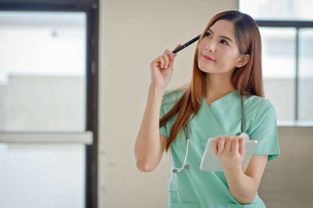 Portrait of a beautiful smiling nurse Thinking showing blank area for sign or copyspaceの写真素材