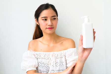 Body lotion Portrait of Beautiful  Woman looking at Camera. Beautiful Asian female model on Whitebackground with clipping path.の写真素材