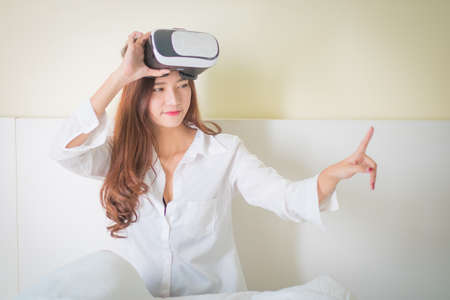 vr box, Asian Woman looking though VR device ,Lighting with sun flareの写真素材