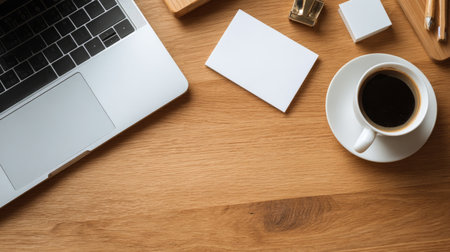 Neat flat lay of wooden office desk with modern laptop, coffee cup, business cards, elegant and simple layout with clean copy space areaの素材