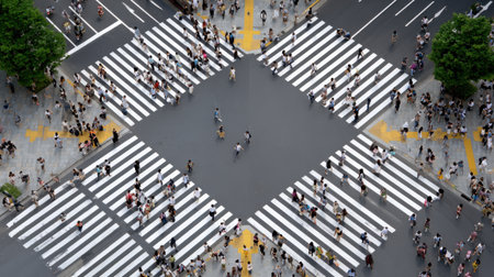 A bustling intersection filled with pedestrians navigating the crosswalks in a vibrant urban setting.の素材