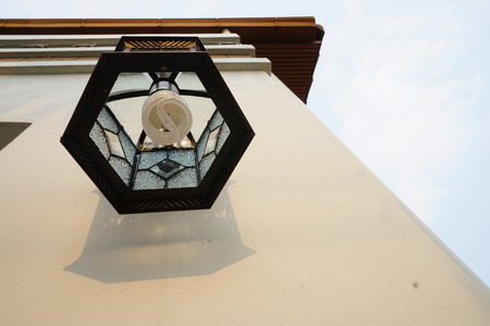 Uprisen angle of outdoor lamp on wall under clear sky and sunlight