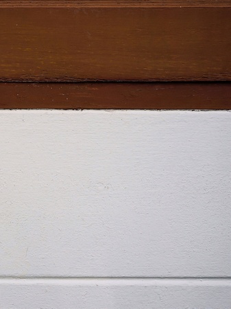 Abstract wooden bar in dark brown above white concrete texture with copy-space for add text Use as background. The image was taken from window edge and new painted wall.の写真素材