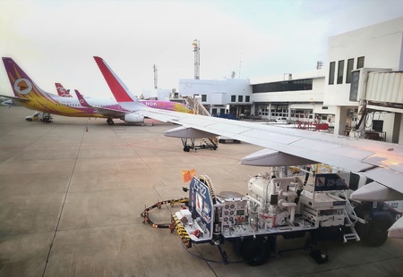 BANGKOK, THAILAND - MAY 20, 2017; Don Mueang International Airport activities - aircraft refueling operation; mini-truck parking beside Nok Air airplane; many planes waiting for boarding at gates, etc.のeditorial素材