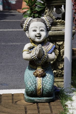 Statue of girl with hands clasped in the Thailand.の写真素材