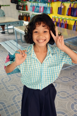 Kid smiling with a table and chairs as a backdrop のeditorial素材
