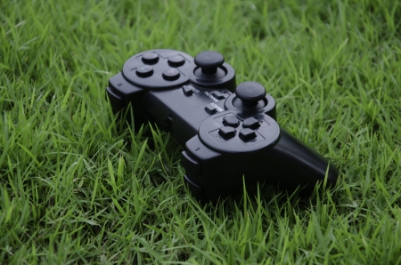 Joystick game controller with grass in the background 