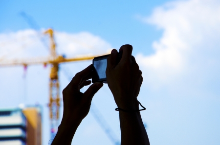 The hand that was holding the camera with a crane in the background 