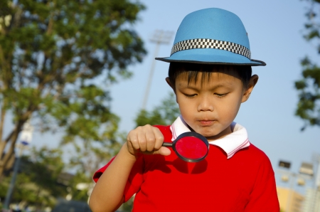 Boy with magnifying glass in the sky as a backdrop  の写真素材