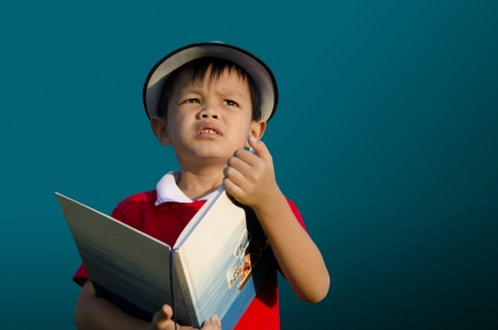 Children reading a book with a dark background の写真素材