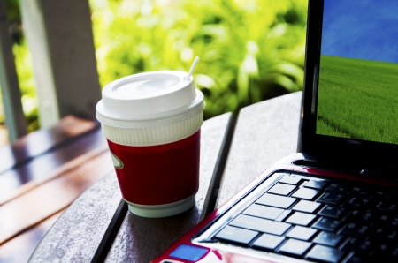 Coffee and laptop on the wooden tableの写真素材