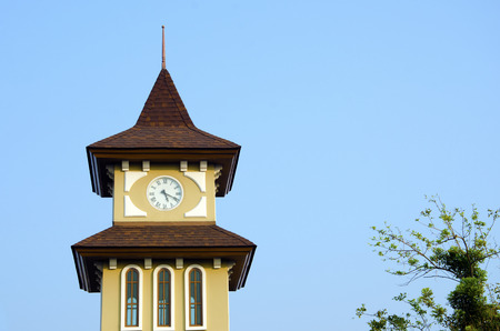 Clock tower with sky and trees in the background  