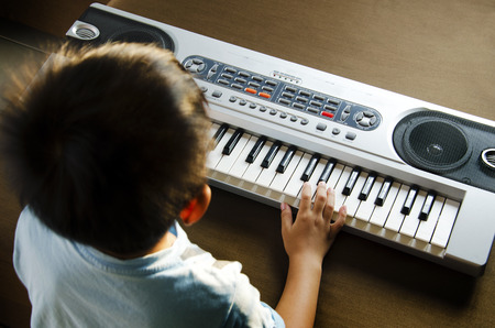 Young man using hands to play the Electone  の写真素材