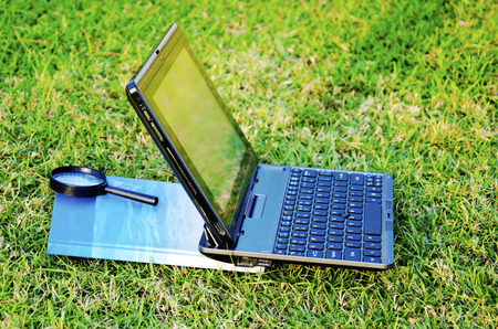 Notebook computers with green grass in the background  