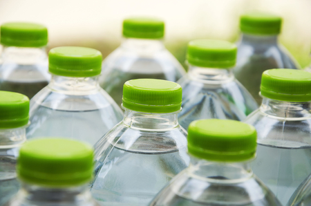 Water bottles with caps made of green plastic.の写真素材