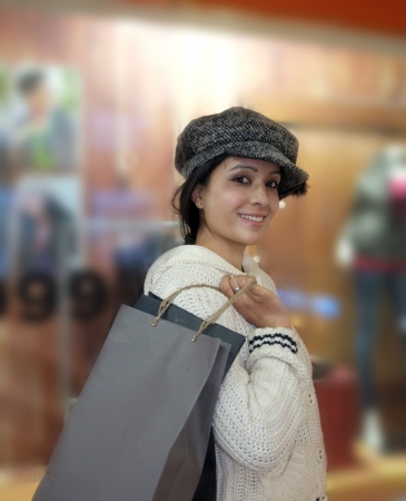 Girl smiling with shopping bags outside a shop.の写真素材