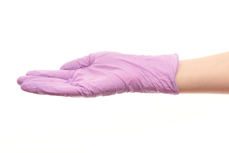 Close up of female doctor's hand in purple sterilized surgical glove against white backgroundの写真素材
