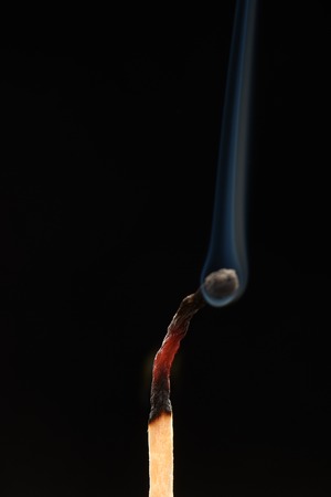Burnt match with smoke isolated on black backgroundの写真素材