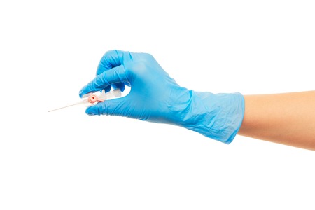 Close up of female doctor's hand in blue sterilized surgical glove with pink plastic catheter against white backgroundの写真素材