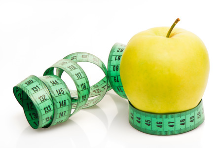 Green apple with measuring tape isolated on white background. Clipping path includedの写真素材