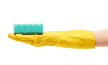 Close up of female hand in yellow protective rubber glove holding green cleaning sponge against white backgroundの写真素材