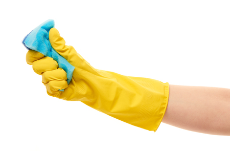 Close up of female hand in yellow protective rubber glove squeezing blue cleaning sponge against white backgroundの写真素材