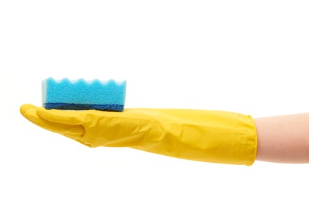 Close up of female hand in yellow protective rubber glove holding blue cleaning sponge against white backgroundの写真素材