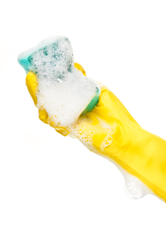 Close up of female hand in yellow protective rubber glove holding green cleaning sponge in foam against white backgroundの写真素材