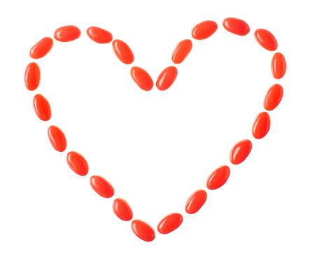 Heart made of red candies isolated on white backgroundの写真素材