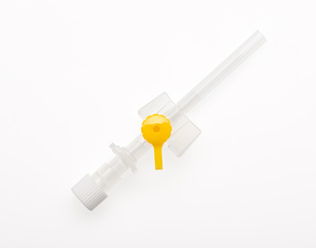 Yellow plastic catheter with needle closed by protective cap isolated on white background. Clipping path included.の写真素材
