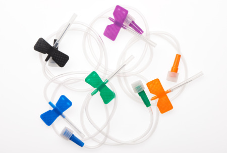 Black, orange, green, blue and purple butterfly plastic catheters with needles closed by protective caps isolated on white background. Clipping path included.の写真素材