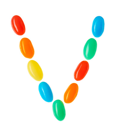 V letter made of multicolored candies isolated on white backgroundの写真素材