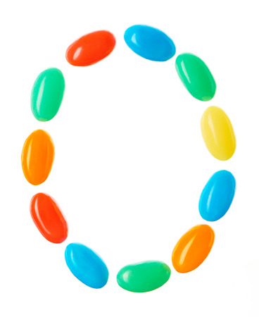 O letter made of multicolored candies isolated on white backgroundの写真素材