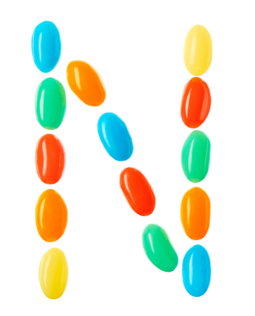 N letter made of multicolored candies isolated on white backgroundの写真素材