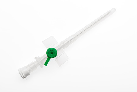 Green plastic catheter with needle closed by protective cap isolated on white background.の写真素材