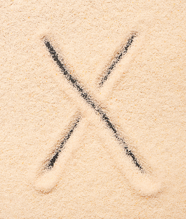 X letter written on sandの写真素材