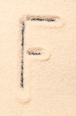 F letter written on sandの写真素材