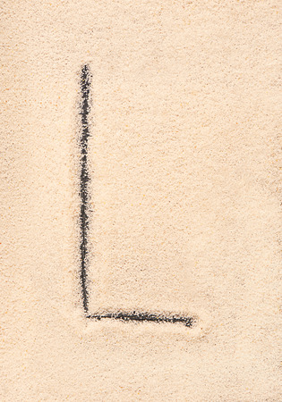 L letter written on sandの写真素材