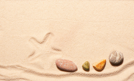 Mark of starfish and sea stones on sand. Summer beach background. View from aboveの写真素材