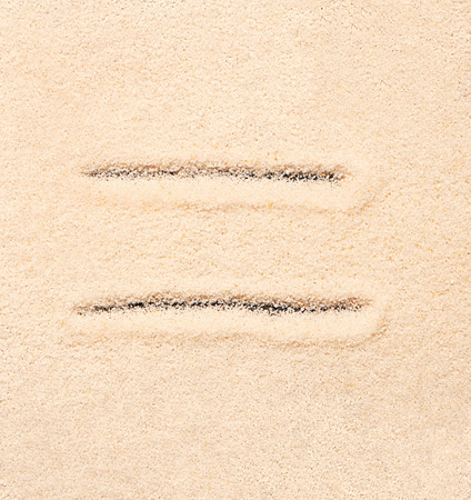 Equal symbol written on sand. Summer beach backgroundの写真素材