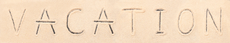 Vacation lettering drawn on sand. Summer beach backgroundの写真素材