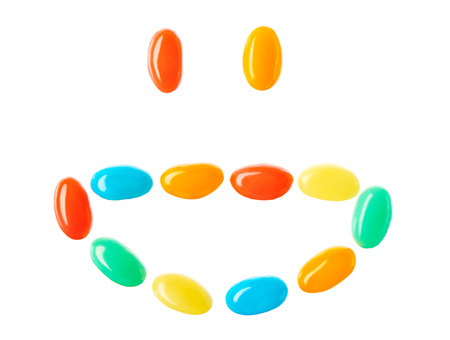 Happy smiling smiley made of multicolored candies isolated on white backgroundの写真素材