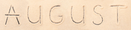 August lettering drawn on sand. Summer beach backgroundの写真素材