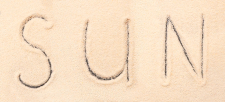 Sun lettering drawn on sand. Summer beach backgroundの写真素材