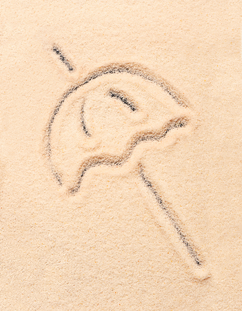 Beach umbrella drawn on sand. Summer beach backgroundの写真素材